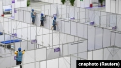 资料照：中国广东广州的工人在琶洲国际会展中心为新冠疫情修建方舱。（2022年4月10日）