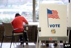 Seorang pemilih memberikan suaranya di markas Pengawas Pemilu Orange County pada malam pemilihan paruh waktu AS, di Orlando, Florida, 7 November 2022. (Greg Newton / AFP)