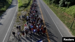 Những di dân người Trung Mỹ, một phần trong đoàn người đang cố gắng đến được Mỹ, đi bộ dọc theo một con đường trong khi họ tiếp tục hành trình, ở Ciudad Hidalgo, Mexico, ngày 26 tháng 10, 2018.