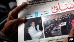 一名埃及人在开罗举着报道穆斯林兄弟会精神领袖巴迪被捕的报纸(2013年8月20日)