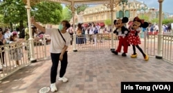 香港迪士尼乐园重开后加强防疫措施,游客与卡通人物拍照时要保持社交距离 (美国之音/汤惠芸)