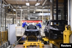 上汽集团在临港的汽车生产基地里,工人在生产线上工作。(2022年4月23日)