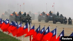 资料照:台湾士兵在一次军演中驾驶军车驶过台湾旗帜。(2010年1月27日)