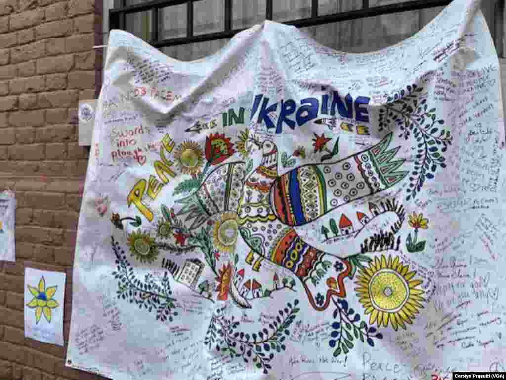 A banner reading “Peace in Ukraine” hangs on the wall outside the Ukraine Embassy, Washington, D.C., March 9, 2022. People walking by can leave comments on the banner. (Carolyn Presutti/VOA)