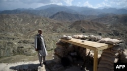 资料照片:2018年7月7日,阿富汗东部楠格哈尔省,一名当地警察在检查站巡逻。