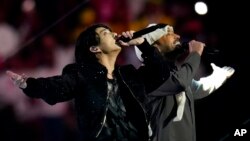 Personil BTS Jung Kook (kiri), bersama penyanyi Qatar, Fahad Al Kubaisi di acara pembukaan Piala Dunia 2022 (dok: AP/Manu Fernandez)