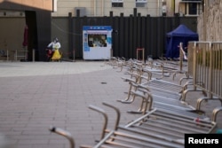 身穿防护服的工作人员在等候上海市民前来做新冠核酸检测。(2022年12月22日)