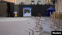 身穿防护服的工作人员在等候上海市民前来做新冠核酸检测。(2022年12月22日)