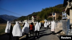 中国浙江桐庐县的一家人在给刚刚离世的一位亲人送葬。(路透社2023年1月9日照片)