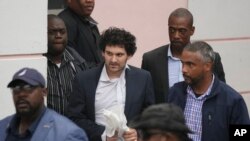 FTX 创始人山姆·班克曼-弗里德（中）在同意被引渡到美国后，于2022年12月21日从巴哈马拿骚地方法院护送出来。（美联社照片）