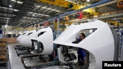 资料照：上海一家工厂的工人在高铁火车配件生产线上。（2022年7月21日）