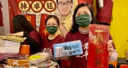 民主党前中西区区议员伍凯欣手持林卓廷写的挥春,以及民主党地区组织”解围”设计的口罩 (美国之音/汤惠芸)