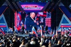 2022年3月18日,俄罗斯总统普京在纪念克里米亚“回归”八周年的音乐会上发表演讲时出现在大屏幕上,背景是一面写着“为了俄罗斯”的横幅。