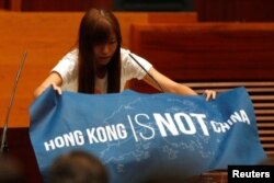 香港立法会新一届非建制派议员游蕙祯在就职宣誓仪式上展示出用英文写的“香港不是中国”的蓝色旗帜(2016年10月12日)