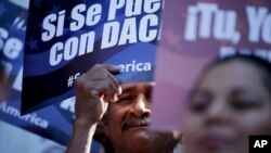 美国加州圣迭戈一名男子站在标语牌中间,支持奥巴马总统有关保护超过4百万生活在美国的非法移民,不将他们驱逐出境的计划。(资料照片)