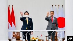 2022年4月29日,日本首相岸田文雄(左)与印尼总统维多多在印尼西爪哇茂物市总统府会面时向人群挥手致意。(照片由印尼总统府发布。)