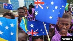 资料照:所罗门群岛的学童手举澳大利亚与所罗门群岛的国旗。