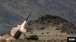 资料照片:在加州二十九棕榈村美国海军陆战队空地作战中心举行的一次演习期间,一支海军陆战队炮兵连发射HIMARS多管火箭炮。(2014年5月18日)