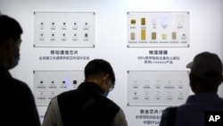 资料照片:2020年9月19日,人们在北京举行的中国北京国际高新技术博览会上观看清华紫光集团制造的半导体。(美联社照片)