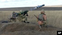 资料照:由乌克兰国防部提供的图像显示,一名乌克兰士兵在顿涅茨克地区举行的军事演习中使用携带美国标枪导弹的发射器。(2022年1月12日)