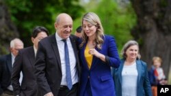 参加在德国小镇旺格尔斯召开的2022年七大工业国集团外长会议的各国外长。法国外长让-伊夫∙勒德里昂(Jean-Yves Le Drian)(前左)和加拿大外长茉兰妮娅·茱莉(Melanie Joly)边走边谈。