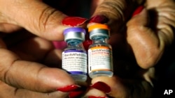 资料照片:一名护士拿着辉瑞/生物科技公司的COVID-19疫苗针剂,一瓶用于5到11岁儿童,另一瓶用于成年人。(2022年2月8日)