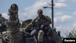 乌克兰顿涅茨克地区的一名乌军士兵坐在坦克车顶上。(2022年5月25日)