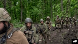 乌克兰军人在乌东哈尔科夫的树林里行进。(2022年5月15日)