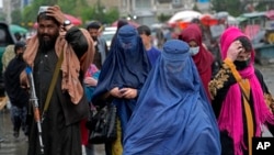 阿富汗妇女在塔利班看守下在首都喀布尔的一个市场上行走(2022年5月3日)