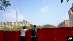 中国广东广州被封的海珠区居民从围栏里向往张望。(2022年11月11日)