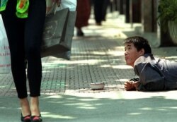 资料照:上海街头的一名残疾乞讨者