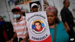 2022 年 12 月 16 日,在委内瑞拉加拉加斯,一名妇女举着一张要求出生于哥伦比亚的商人亚历克斯·萨博获释的海报参加示威游行。