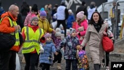 资料照片:志愿者帮助逃入波兰境内的乌克兰难民家庭。(2022年3月6日)