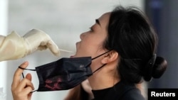 一名上海女子在接受新冠核酸检测。(2022年12月7日)