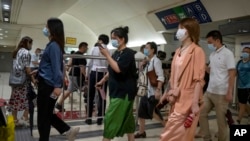 2022年8月9号,北京市民匆匆忙忙搭乘地铁去上班。2022年夏天全中国有1100多万大学生毕业进入就业市场。严格的新冠封控措施使工厂生产部景气,大学生难以找到工作。