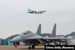 珠海航空展上展示的C-919远航大型客机在一架中国空军战机上空飞过。(2022年11月8日)