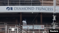 停泊在日本横滨港的“钻石公主号”游轮上一名身穿防护服的工作人员(2020年2月20日)