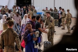 英国公民在苏丹的一个军事基地走向接他们回国的英国皇家空军。(2023年4月27日)