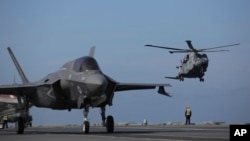 资料照片：在葡萄牙附近海域举行的北约“坚定捍卫者”演习期间，一架F-35战斗机在英国皇家海军“伊丽莎白号”航空母舰甲板上滑行。(2021年5月27日)