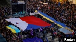 2022 年 10 月 30 日,在捷克共和国布拉格举行的亲政府和反战抗议集会上,示威者举着旗帜。