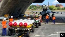 台湾军队士兵站在F16V战机前，准备进行装载美制AGM-84鱼叉反舰导弹及AIM-120和AIM-9空空导弹的训练。（2022年9月16日）