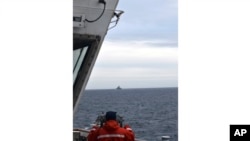 资料照片:在美国海岸警卫队提供的这张照片中,海岸警卫队金博尔号巡逻舰的一名船员在白令海观察一艘外国船只。(2024年7月10日)