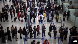 资料照片: 上海浦东国际机场候机大厅,旅客在排队办理登记手续