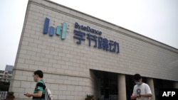 Dua karyawan berjalan di luar kantor pusat ByteDance, pemilik aplikasi berbagi video TikTok, di Beijing, China (foto: dok).