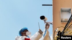 黑龙江省牡丹江市一个住宅小区里有身穿防护服的人在安装监控摄像头。（2022年4月14日）