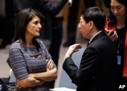 美国常驻联合国代表妮基·黑利与中国常驻联合国副代表吴海涛在联合国总部交谈。(2017年12月22日)