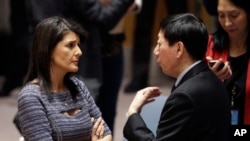 美国常驻联合国代表妮基·黑利与中国常驻联合国副代表吴海涛在联合国总部交谈。(2017年12月22日)