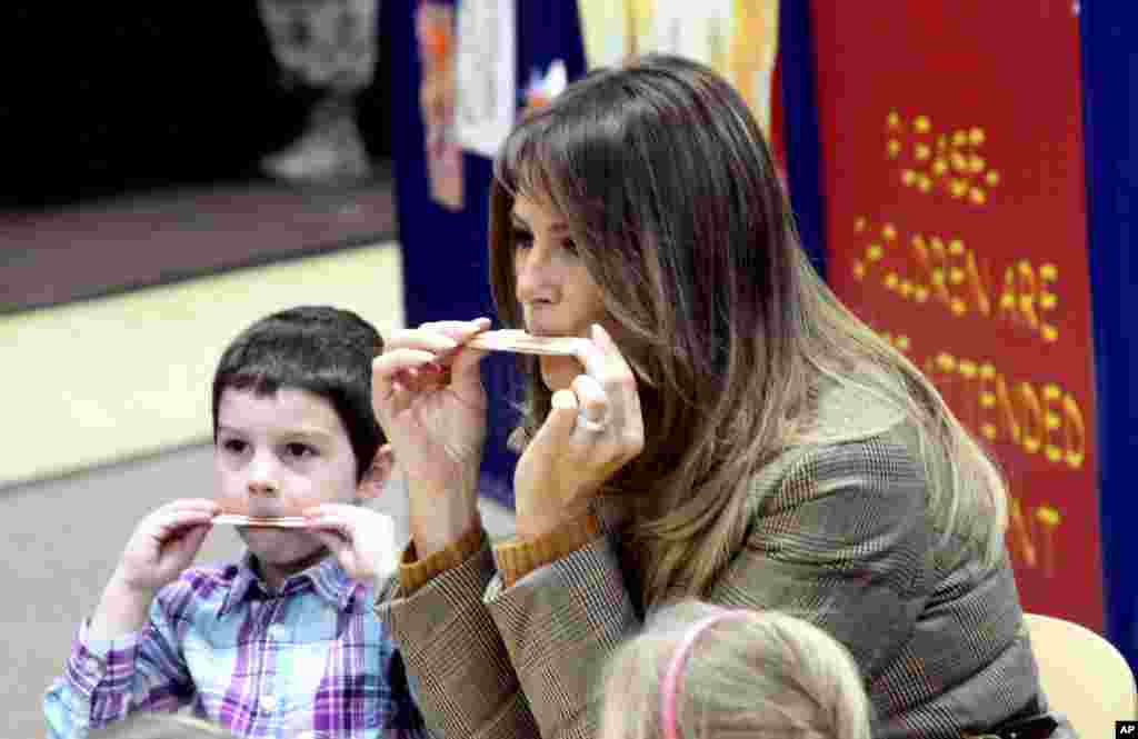 2017年11月10日,在美国阿拉斯加的安克雷奇的埃尔门多夫 - 理查森联合基地,美国第一夫人梅拉尼亚·川普和军人的孩子们一起吹口琴。