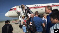 旅客在平壤国际机场登上前往北京的飞机