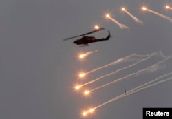 2013年4月17日,台湾在澎湖一带举行“汉光军事演习”。图为一架AH-1W攻击直升机释放光束躲避敌方导弹。